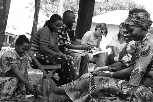 Women's Emancipation and Development Agency (WOMEDA) Executive Director Juma Massisi (seated, center) facilitates conversation among women and Amizade students in Kayanga, Tanzania, as part of research that supported a successful United States Agency for International Development grant award for WOMEDA.